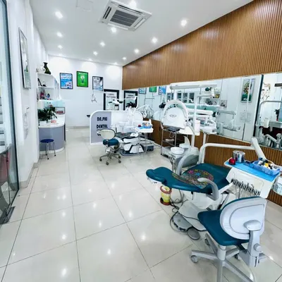 Phòng điều trị với các ghế nha khoa và vách ngăn in chữ DR. PHI DENTAL